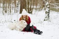 Pretty Young Woman in Winter Forest Walking with her Dog White Samoyed Royalty Free Stock Photo