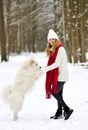 Pretty Young Woman in Winter Forest Walking with her Dog White Samoyed Royalty Free Stock Photo