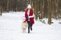 Pretty Young Woman in Snowy Winter Forest Park Walking Playing with her Dog Royalty Free Stock Photo