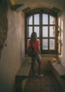 Pretty young woman standing by a window looking at the landscape. Royalty Free Stock Photo