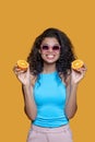 Pretty young woman in sunglasses with orange in hands