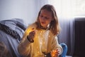 Pretty young woman in sweater holding glowing garland indoor