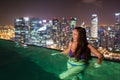 Pretty young woman is swimming at the infinite pool on the rooftop Royalty Free Stock Photo