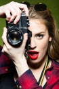 Pretty young woman taking photos with a retro camera. Royalty Free Stock Photo