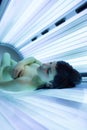 Pretty, young woman tanning her skin in a modern solarium Royalty Free Stock Photo