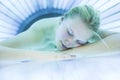 Pretty, young woman tanning her skin in a modern solarium shall