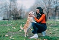 Young woman tenderly caresses her two dogs.