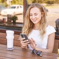 Pretty young woman texting by phone. Happy female person Royalty Free Stock Photo