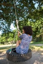 Pretty young woman in tire swing Royalty Free Stock Photo