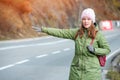 Woman tourist hitch-hiking on the road Royalty Free Stock Photo