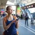 Pretty, young woman in a trainstation, waiting for her train