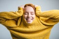 Fashion young woman pulling yellow sweater and having fun over white background Royalty Free Stock Photo