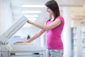 Pretty young woman using a copy machine Royalty Free Stock Photo