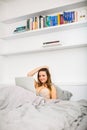 Pretty, young woman using her laptop computer in bed Royalty Free Stock Photo