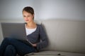 Pretty, young woman using her laptop computer at home Royalty Free Stock Photo