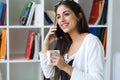 Pretty young woman using her mobile phone in the office. Royalty Free Stock Photo