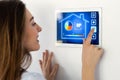 Pretty young woman using the home automation system on digital tablet to regulate the temperature Royalty Free Stock Photo