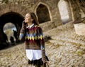 Pretty young woman walking in autumn park and using a mobile phone Royalty Free Stock Photo