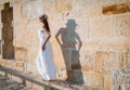 Pretty young woman walking near the stone wall Royalty Free Stock Photo