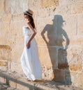 Pretty young woman walking near the stone wall Royalty Free Stock Photo