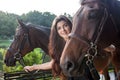 Pretty young woman walking two horses Royalty Free Stock Photo