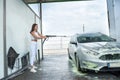 Pretty young woman washing her car in car wash station Royalty Free Stock Photo