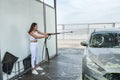 Pretty young woman washing her car in car wash station Royalty Free Stock Photo