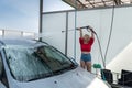 Pretty young woman washing her car in car wash station Royalty Free Stock Photo