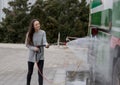 Woman washing truck with high pressure water jet