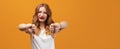 Pretty young woman with wavy redhead, wearing white t-shirt showing thumb down. Copy space Royalty Free Stock Photo