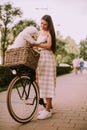 Young woman with white bichon frise dog in the basket of electric bike Royalty Free Stock Photo
