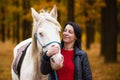 A pretty young woman and a white horse it\'s the love of a lifetime