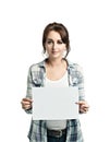 Pretty young woman in a white shirt and a light blue checkered shirt holds an empty sheet in her hands Royalty Free Stock Photo