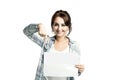 Pretty young woman in a white shirt and a light blue checkered shirt holds an empty sheet in her hands Royalty Free Stock Photo