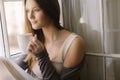 Pretty young woman by the window Royalty Free Stock Photo