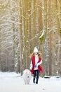 Pretty Young Woman in Winter Forest Park Walking with her Dog White Samoyed Royalty Free Stock Photo