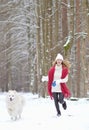 Pretty Young Woman in Winter Forest Walking with her Dog White Samoyed Royalty Free Stock Photo