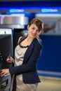 Pretty, young woman withdrawing money from her credit card