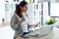 Pretty young woman working with laptop and documents in the kitchen at home Royalty Free Stock Photo