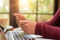 Pretty Young woman hands holding a credit card and using laptop Royalty Free Stock Photo