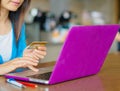 Pretty Young womans hands holding a credit card and using laptop computer for online shopping. Royalty Free Stock Photo