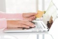 Pretty Young womans hands holding a credit card and using laptop Royalty Free Stock Photo