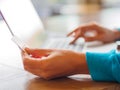 Pretty Young womans hands holding a credit card and using laptop computer for online shopping. Royalty Free Stock Photo