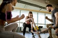 Young woman with battle ropes exercise in the fitness gym witth support from her friends