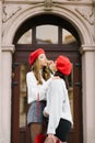 young women in berets blow each other a kiss