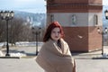 Pretty young women with red hair in beautiful beige scarf and grey coat posing in park. Royalty Free Stock Photo