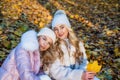 Pretty young women in stylish warm clothing sit on fallen leaves autumn season, womenswear