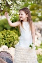 Prettyl smiling little girl in cream dressin the blossom garden Royalty Free Stock Photo