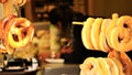 Pretzels hang from tiered stands with bokeh effect woman in background