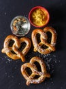 Pretzels and mustard on slate table Royalty Free Stock Photo